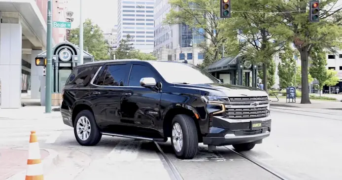 luxury black suv turning the corner to complete an airport transfer