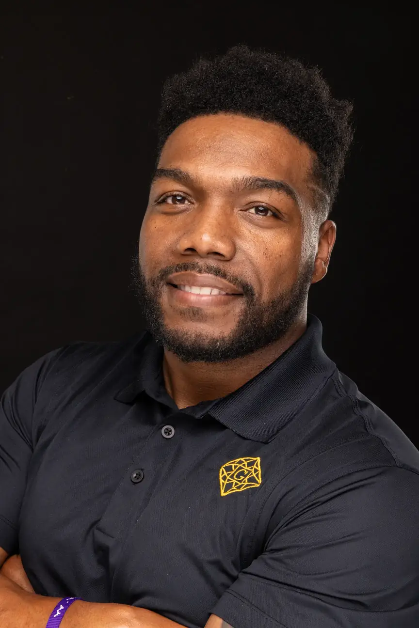 a young black man, smiling, with a short high top fade