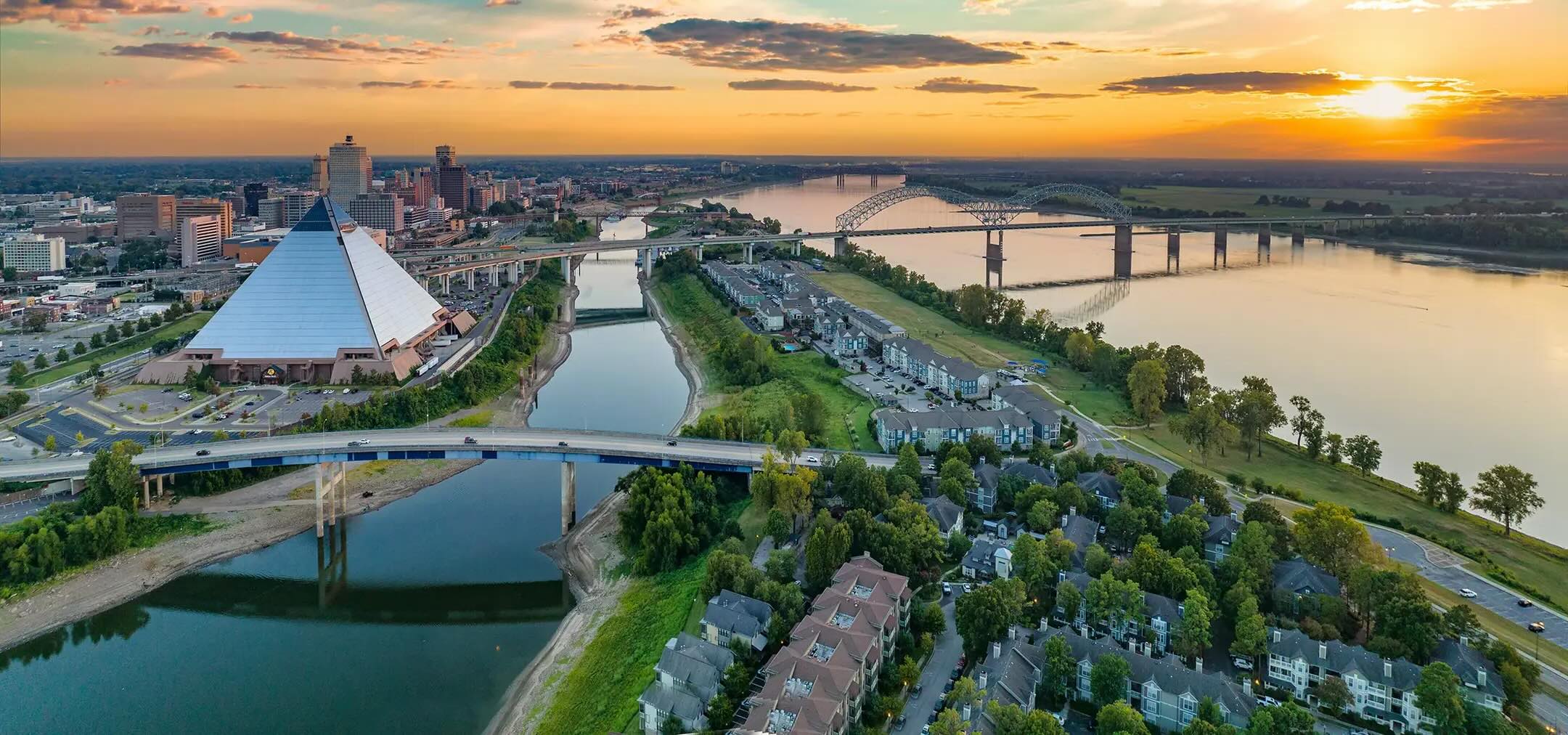 skyline view of memphis, with a large pyramid building and the Herman de Soto Bridge, which stretches across the Mississippi River